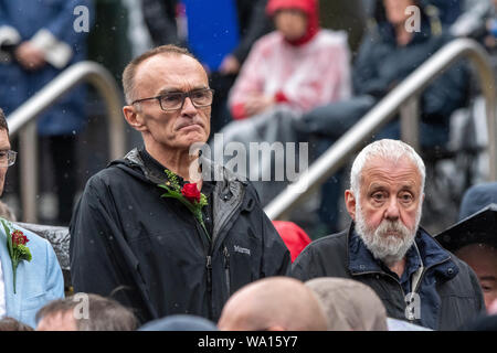 Manchester, UK. 16 August 2019. Protestors and demonstrators commemorate the 200th anniversary of the Peterloo massacre in Manchester. Film director Danny Boyle joined performers marking the event whilst a crowd of thousands braved torrential rain and wind. Credit: Benjamin Wareing/ Alamy Live News Stock Photo