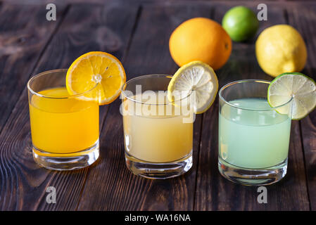 Assortment of citrus juices on the wooden background Stock Photo