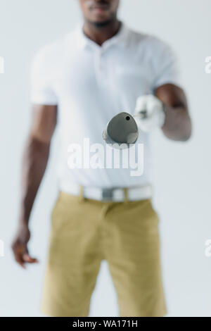 selective focus of african american sportsman showing golf club isolated on grey