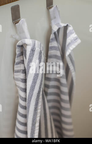 Two kitchen towels hanging on a hooks in a kitchen close-up Stock Photo