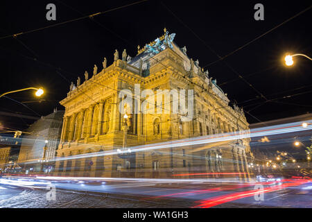 Light trails in front of the illuminated National Theatre building in Prague, Czech Republic, at night.