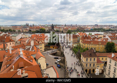 View of crowds of tourists at the Charles Bridge (Karluv most), Mala Strana (Lesser Town) and Old Town districts and Vltava River in between in Prague Stock Photo