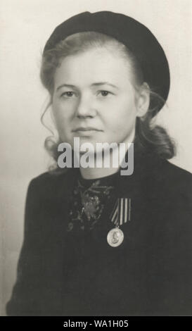 Vintage portrait of young woman with a medal 'For the Victory over Germany in the Great Patriotic War 1941–1945', Germany, 1945 Stock Photo