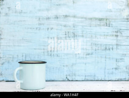 Enameled mugs in retro style on an old wooden background. Selective focus. Stock Photo