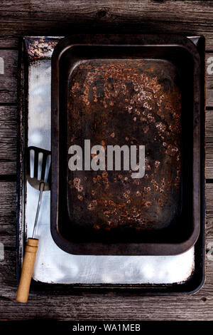 Old vintage baking pan and tins on wooden background. Selective focus. Stock Photo