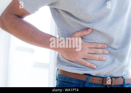Man touching his stomach in pain. Stock Photo