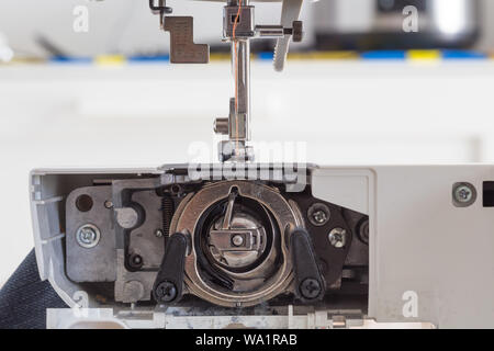 sewing machine with colour thread and needle on a table with blurred background, Tailor's work table, textile or fine cloth making, industrial fabric, Stock Photo