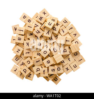Pile of alphabet letters on wooden scrabble pieces, isolated on white background with clipping path. Stock Photo