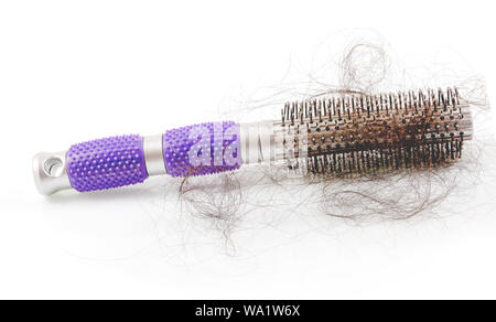 Pile of women's hair loss problem, hairs fall with pink brush on white background. Stock Photo