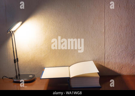 open book and open lamp in dark night on the table, with copy space background. Stock Photo