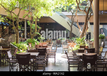 Bangkok, Thailand - May 19, 2019: Groove restaurant interior decorated with living trees and lit with natural light at Central World shopping mall. Stock Photo