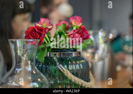Bouquet of red roses on a decorated banquet table in a luxury restaurant. Stock Photo