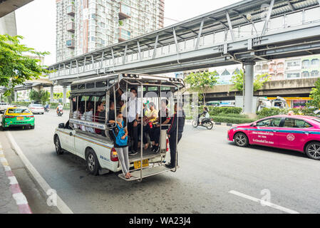Bangkok: a songthaew with passengers in it, on the street in Bangna. The songthaew is one of the regular types of public transport in Thailand. Stock Photo