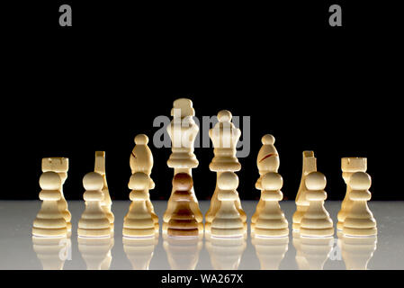 White chess formation with a single black piece as a concept for undercover operations, infiltration, racial tension, ethnic minorities. Stock Photo