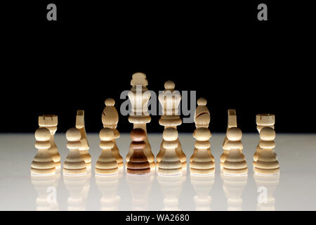 White chess formation with a single black piece as a concept for undercover operations, infiltration, racial tension, ethnic minorities. Stock Photo