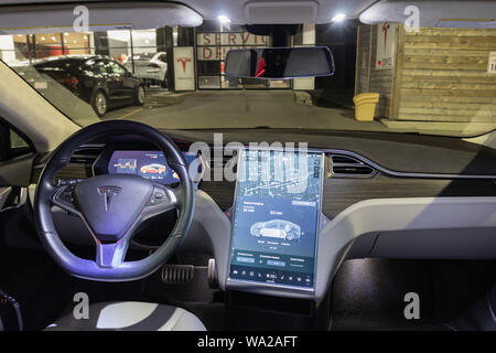 Full-view of Tesla Model S interior, seen a night while vehicle charges at Tesla Supercharger at a service center. Stock Photo