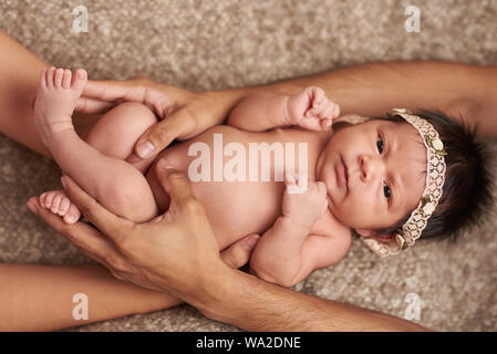 Parent hugging little baby lying on soft bed Stock Photo