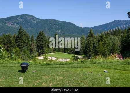 WHISTLER, BC/CANADA – AUGUST 3, 2019: Fairmont Chateau Whistler Golf Club, sunny day on tee box, with sand traps and green. Stock Photo