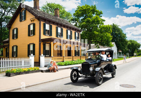 Vintage Ford Model T automobiles transport visitors throughout the historic Greenfield Village at the Henry Ford Museum in Dearborn, Michigan, USA Stock Photo