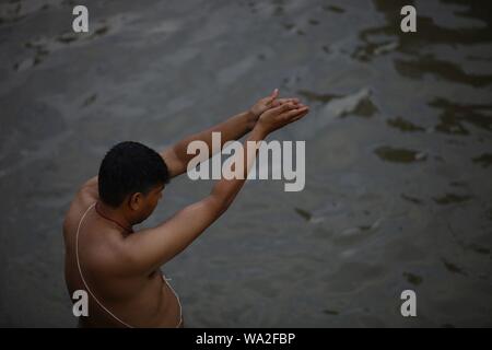 Kathmandu, Nepal. 15th Aug, 2019. A devotee offers prayers after taking holy bath at the bank of Pashupatinath temple on occasion of Janai Purnima festival. (Photo by Archana Shrestha/Pacific Press) Credit: Pacific Press Agency/Alamy Live News Stock Photo