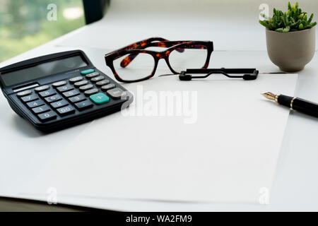 Business objects, clipboard with blank sheet of paper, pen, glasses and calculator on white background Stock Photo