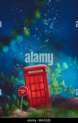 English Red Telephone box underwater. Global warming concept. Conceptual still life with miniatures. Stock Photo