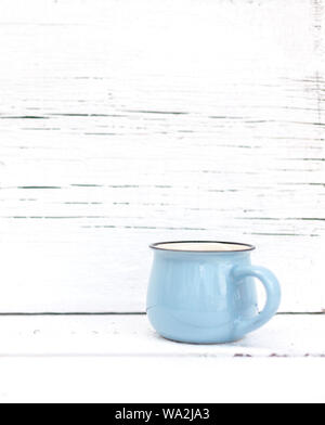 Enameled mugs in retro style on an old wooden background. Selective focus. Stock Photo