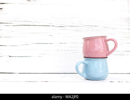 Enameled mugs in retro style on an old wooden background. Selective focus. Stock Photo