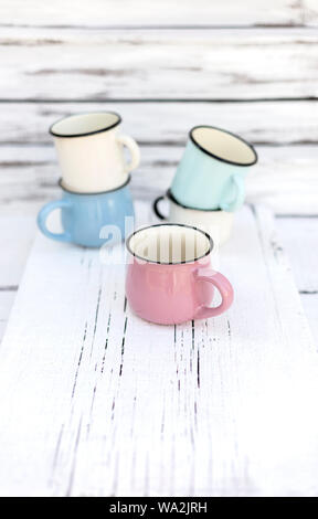 Enameled mugs in retro style on an old wooden background. Selective focus. Stock Photo