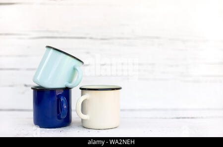 Enameled mugs in retro style on an old wooden background. Selective focus. Stock Photo
