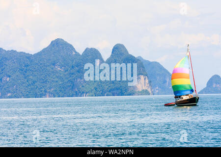 Yacht with colourful multi coloured sails sailing in Phang Nga Bay off Phuket, Thailand Stock Photo