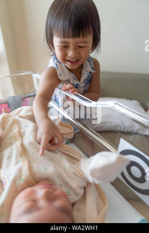 Asian little sister take care her newborn brother. Cute girl and new ...