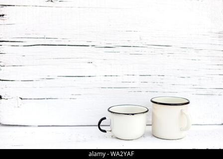 Enameled mugs in retro style on an old wooden background. Selective focus. Stock Photo