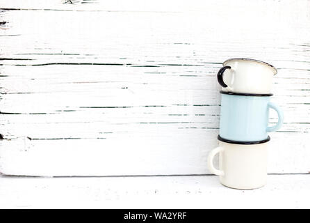 Enameled mugs in retro style on an old wooden background. Selective focus. Stock Photo