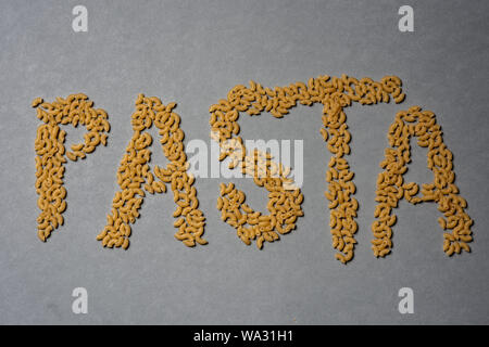 The word pasta written in macaronis on grey background Stock Photo