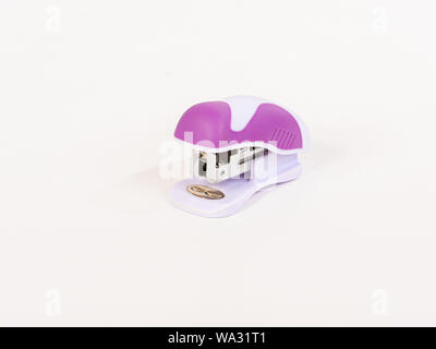 Small, pink stapler with a rounded design on white background. Stock Photo