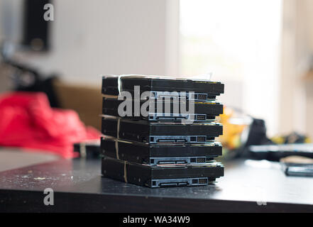 A stack of 3,5 inches SATA hard drives on a table. Stock Photo