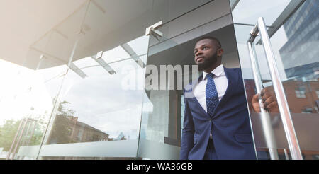 Young african job seeker leaving building after interview Stock Photo