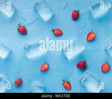 Fresh summer background of strawberries and ice cubes on blue Stock Photo