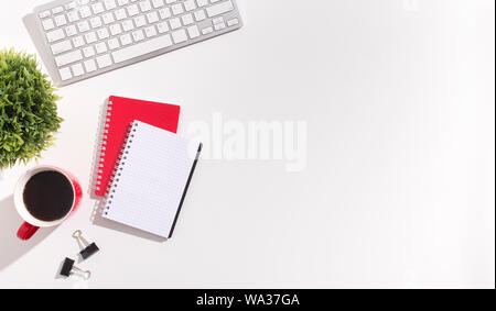 Red and white notebooks and keyboard on white office table Stock Photo