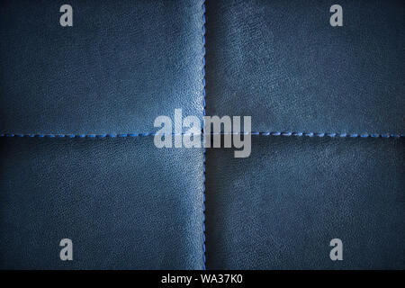 Dark blue artificial textured leather stitched with blue thread. Close-up of sofa surface. View from directly above. Highly detailed background with l Stock Photo