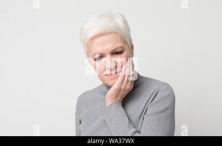 Elderly woman suffering from sudden tooth pain, panorama Stock Photo