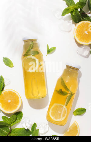 Refreshing cocktail with fresh lemons and mint in bottle on white Stock Photo