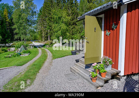 flowers on stairs infront of a red wooden cabin Stock Photo