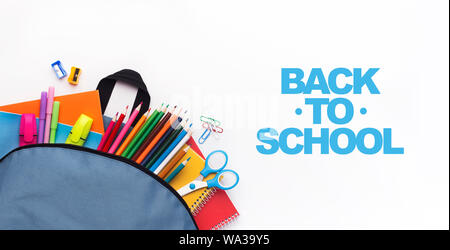 School backpack with colored stationery on white background Stock Photo