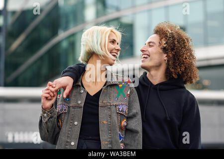 Happy young couple laughing in urban background Stock Photo