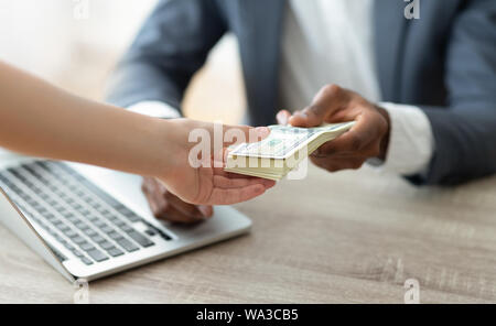 Bank manager holding stack of cash giving credit to customer Stock Photo