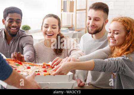 Pizza delivery. Friends taking slices of hot pizza Stock Photo