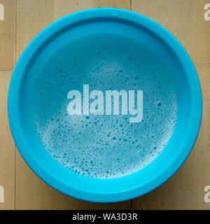 Blue bowl with soapy water and foam Stock Photo