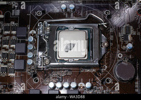 Close up to the thermal paste compound on the top of cpu in the socket. Concept of repairing or upgrading computer hardware Stock Photo